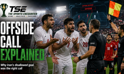 Iranian players in white kits protest an offside decision as the referee and assistant referee signal the call during the Iran vs Egypt World Cup 2026 match.