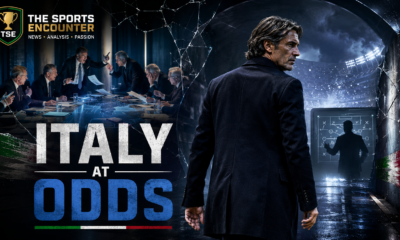 Cinematic VFX image showing a Maldini-inspired Italian football executive walking away from a tense federation crisis scene, with officials arguing in the background, a shadowed coach figure on a tactics board, The Sports Encounter branding, and the headline “Italy at Odds.”