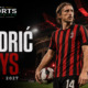 Luka Modrić stands with a football on the San Siro pitch in AC Milan colors after extending his contract through June 2027.