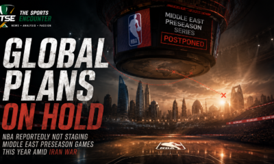 An empty NBA arena displays “Middle East Preseason Series Postponed” above a Gulf skyline, illustrating the reported pause in regional games amid the Iran war.