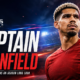 Ronald Araújo appears in a red Liverpool-style kit under dramatic stadium lights beside the headline “Captain to Anfield,” illustrating the Barcelona captain’s reported season-long loan move to Liverpool.