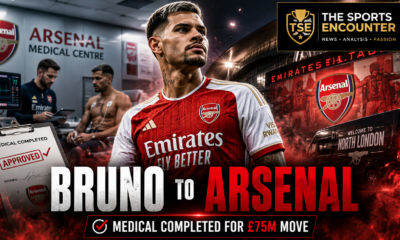 Alt text: Bruno Guimarães wears an Arsenal shirt outside Emirates Stadium after completing his medical for a reported £75 million transfer from Newcastle United.