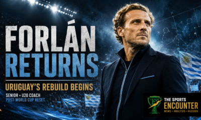 Cinematic Diego Forlán coaching graphic showing the former Uruguay star in a dark touchline jacket under stadium lights, with Uruguay flags, tactical-board markings, the headline “Forlán Returns,” the message “Uruguay’s Rebuild Begins,” and The Sports Encounter logo.