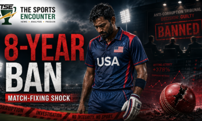 A dejected USA cricketer stands beneath stadium lights after receiving an eight-year ban for match-fixing, with an anti-corruption tribunal backdrop, suspicious betting graphics, a cracked cricket ball, and The Sports Encounter logo.