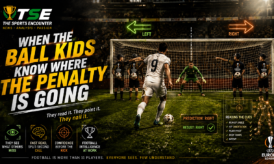 Ball kids behind the goal point toward the predicted penalty direction as a striker prepares to shoot, illustrating how body language, run-up angle, and plant-foot position can reveal where a penalty may be going.