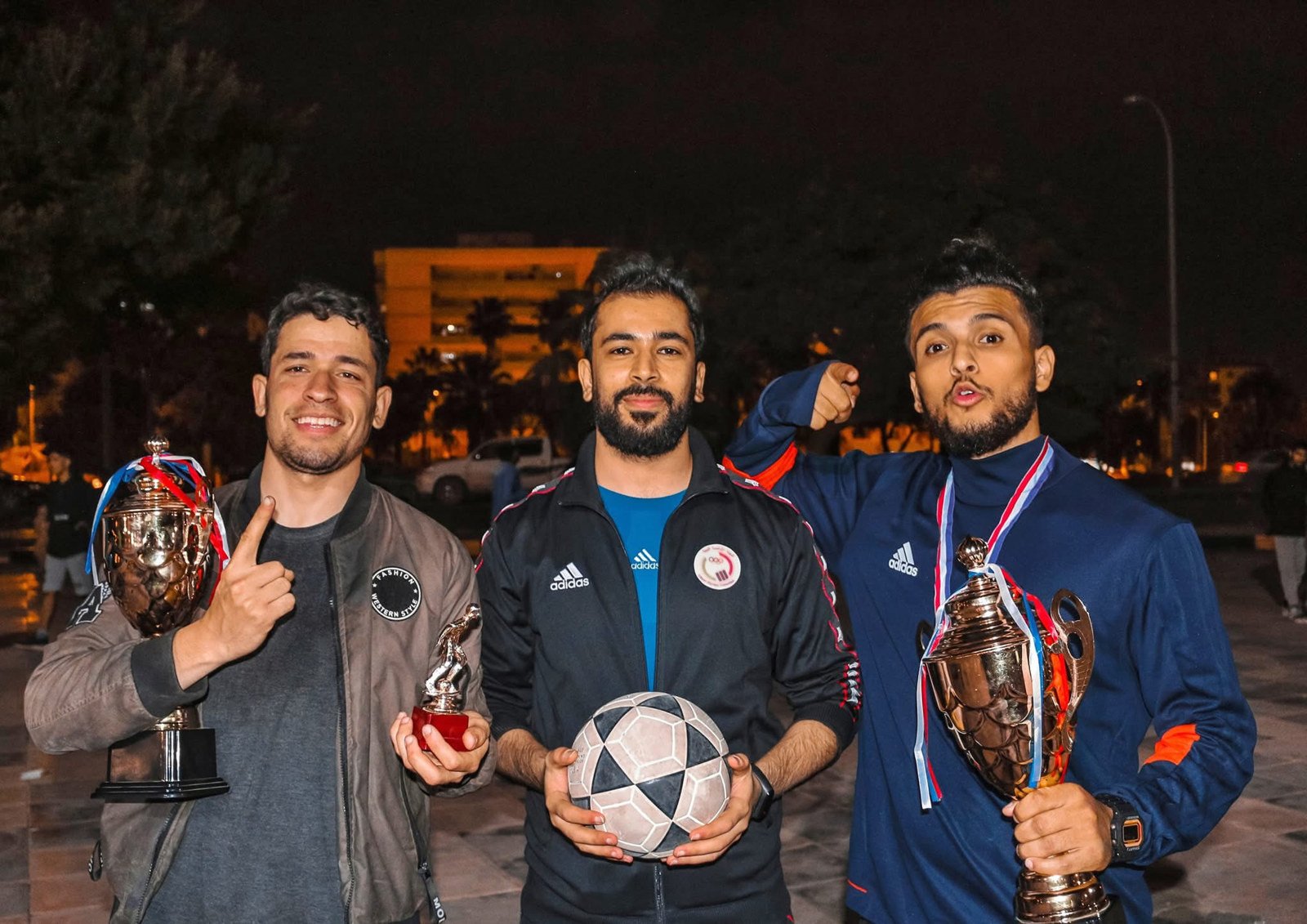 Faraj Rahil with two other freestyle football athletes holding trophies
